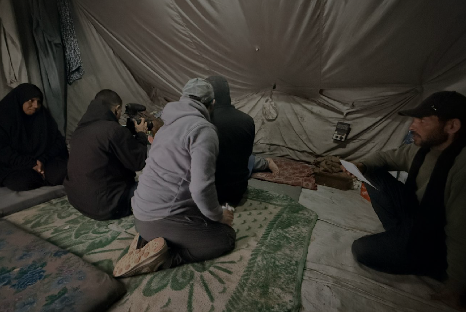 Crew and cast setting up a scene inside the tent